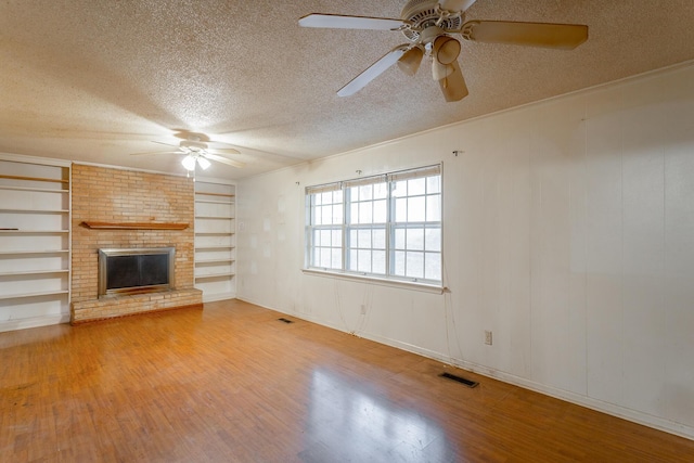 4510 Ravenwood Dr E, Chattanooga, TN 37415 - unfurnished living room with ceiling fan, a textured ceiling, wood finished floors, a fireplace, and crown molding