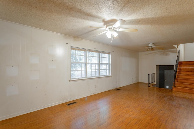 4510 Ravenwood Dr E, Chattanooga, TN 37415 - unfurnished living room featuring a ceiling fan, wood finished floors, stairs, and a textured ceiling