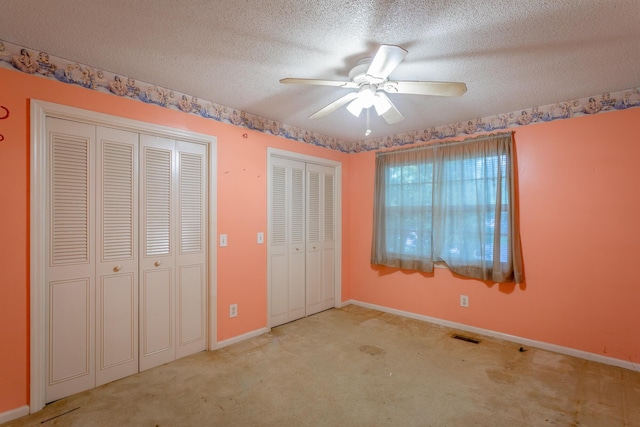 4510 Ravenwood Dr E, Chattanooga, TN 37415 - unfurnished bedroom with two closets, carpet floors, a textured ceiling, baseboards, and a ceiling fan