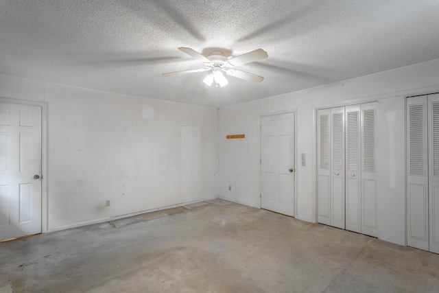 4510 Ravenwood Dr E, Chattanooga, TN 37415 - unfurnished bedroom with concrete floors, a textured ceiling, ceiling fan, and multiple closets