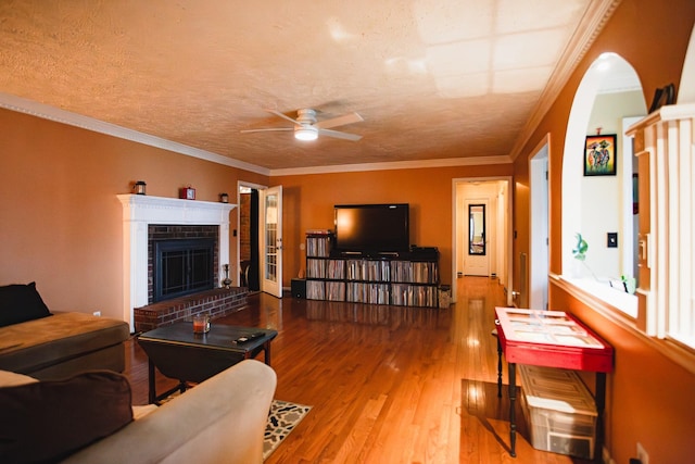 2014 Saddlebrook Dr, Murfreesboro, TN 37129 - living area with a ceiling fan, wood finished floors, a brick fireplace, arched walkways, and ornamental molding