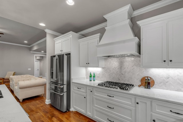 1132 Pretender Way, Columbia, TN 38401 - kitchen with stainless steel appliances, premium range hood, white cabinetry, ornamental molding, and decorative backsplash