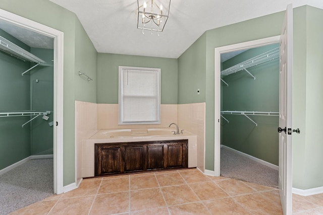 829 Navajo Trl, Mcminnville, TN 37110 - bathroom with a garden tub, a walk in closet, a chandelier, and tile patterned flooring
