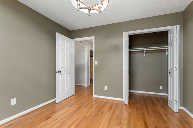 829 Navajo Trl, Mcminnville, TN 37110 - unfurnished bedroom featuring light wood-type flooring, a chandelier, baseboards, and a closet