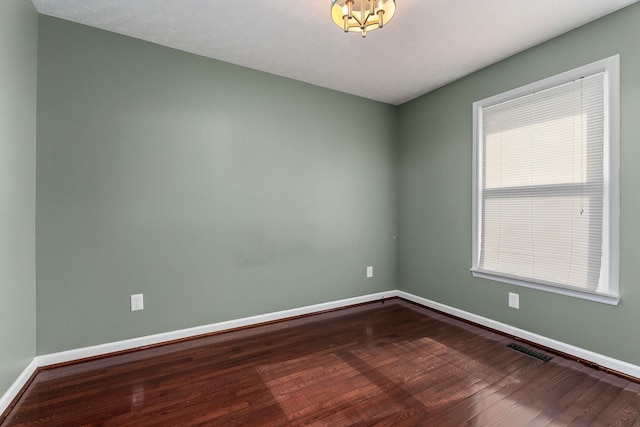 829 Navajo Trl, Mcminnville, TN 37110 - spare room with dark wood-style flooring, baseboards, and a chandelier