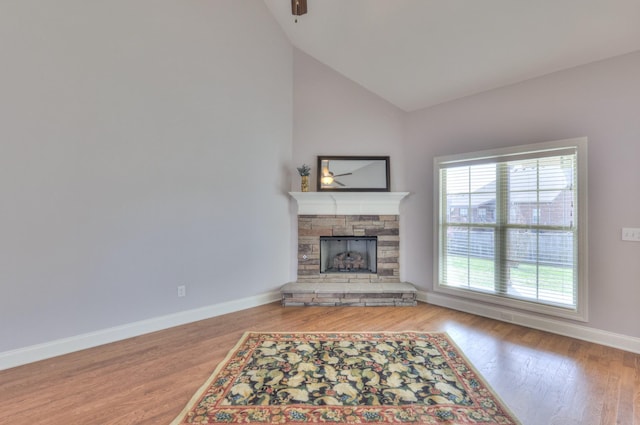 5502 Reflection Rd, Smyrna, TN 37167 - unfurnished living room with a stone fireplace, a ceiling fan, vaulted ceiling, wood finished floors, and baseboards