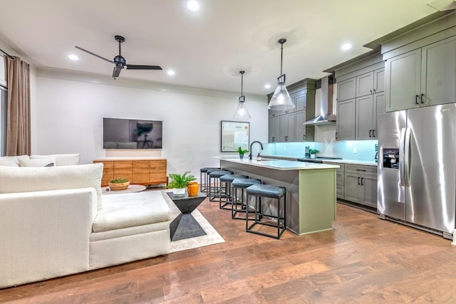 1108 Greenwood Ave, Nashville, TN 37206 - kitchen featuring stainless steel refrigerator with ice dispenser, wall chimney range hood, light countertops, a ceiling fan, and a kitchen bar