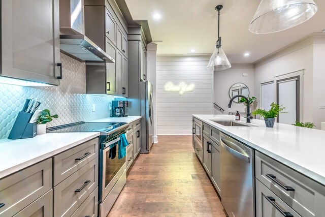 1108 Greenwood Ave, Nashville, TN 37206 - kitchen featuring appliances with stainless steel finishes, a sink, wall chimney exhaust hood, gray cabinetry, and light wood finished floors
