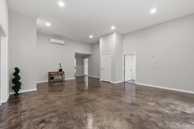 176 S Palmers Chapel Rd, White House, TN 37188 - unfurnished living room featuring a wall unit AC, concrete floors, recessed lighting, baseboards, and a towering ceiling