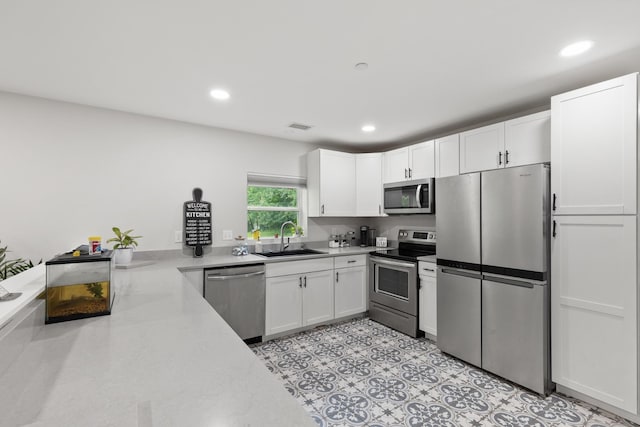 176 S Palmers Chapel Rd, White House, TN 37188 - kitchen featuring stainless steel appliances, a sink, white cabinetry, and recessed lighting