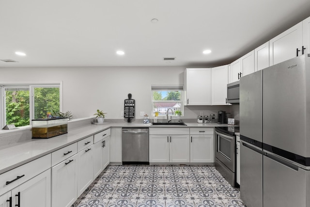 176 S Palmers Chapel Rd, White House, TN 37188 - kitchen featuring appliances with stainless steel finishes, a sink, white cabinets, recessed lighting, and light countertops