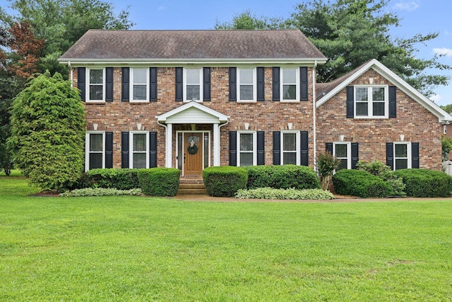 2723 Nottingham Ct, Thompsons Station, TN 37179 - colonial house featuring a front lawn, brick siding, and a shingled roof