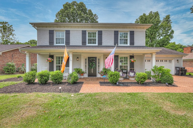 1027 Boxwood Dr, Franklin, TN 37069 - view of front facade with a porch, brick siding, an attached garage, and a front lawn