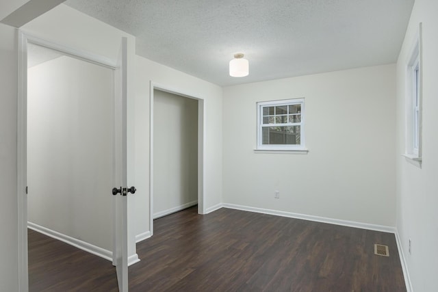 1313 W 46th St, Chattanooga, TN 37409 - unfurnished bedroom with dark wood finished floors, baseboards, a textured ceiling, and a closet