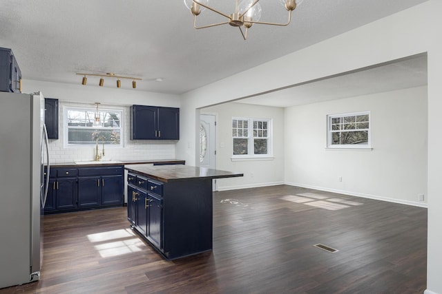 1313 W 46th St, Chattanooga, TN 37409 - kitchen with freestanding refrigerator, blue cabinets, a sink, wood counters, and a chandelier