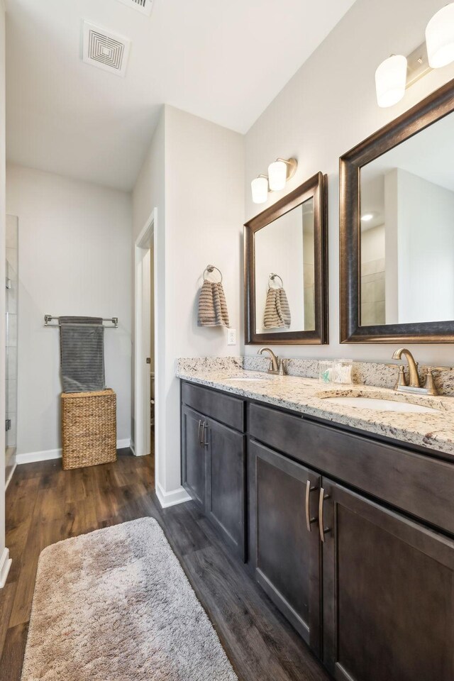 4913 Turquoise Ln, Murfreesboro, TN 37129 - full bathroom featuring wood finished floors, double vanity, baseboards, and tiled shower