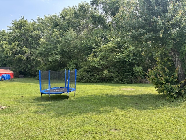 1040 Rebecca Dr, Burns, TN 37029 - view of grassy yard featuring a trampoline