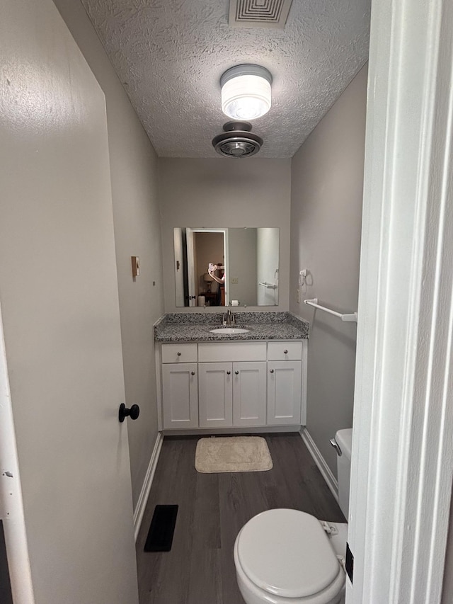 1040 Rebecca Dr, Burns, TN 37029 - bathroom with toilet, wood finished floors, vanity, baseboards, and a textured ceiling