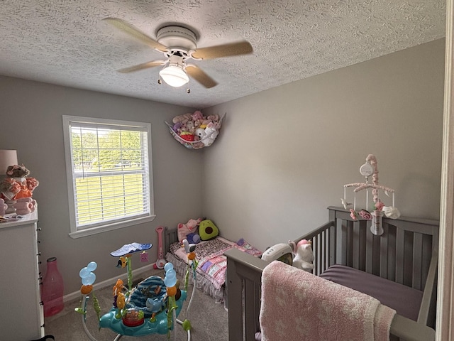 1040 Rebecca Dr, Burns, TN 37029 - bedroom featuring a textured ceiling, carpet, a nursery area, ceiling fan, and baseboards