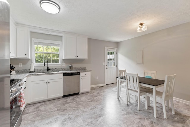 1040 Rebecca Dr, Burns, TN 37029 - kitchen featuring stainless steel appliances, a sink, baseboards, a textured ceiling, and light stone counters