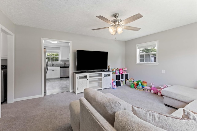1040 Rebecca Dr, Burns, TN 37029 - living room with light carpet, ceiling fan, baseboards, and a textured ceiling