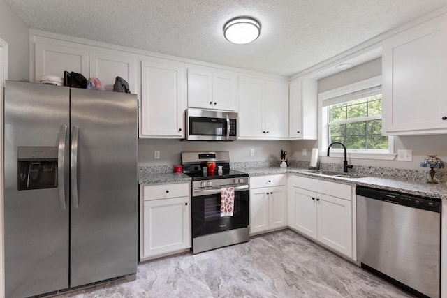 1040 Rebecca Dr, Burns, TN 37029 - kitchen with stainless steel appliances, a sink, white cabinetry, light stone countertops, and a textured ceiling