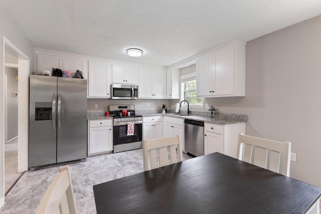 1040 Rebecca Dr, Burns, TN 37029 - kitchen featuring stainless steel appliances, a sink, and white cabinetry