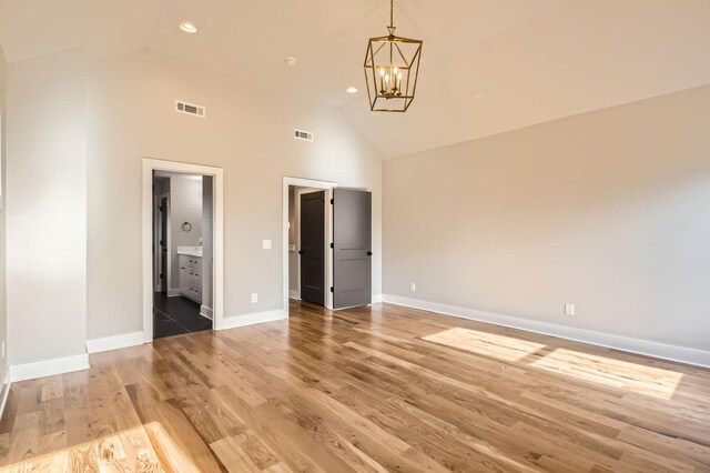 549B Stevenson St, Nashville, TN 37209 - unfurnished bedroom with high vaulted ceiling, a chandelier, baseboards, light wood-style flooring, and ensuite bathroom