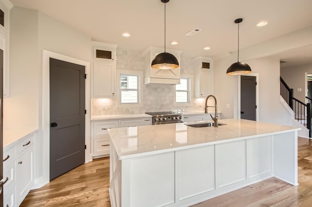 549B Stevenson St, Nashville, TN 37209 - kitchen featuring a sink, stainless steel range, light wood-style flooring, white cabinets, and decorative backsplash