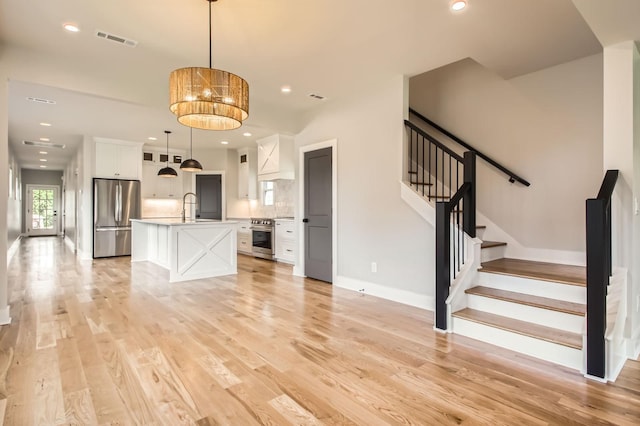 549B Stevenson St, Nashville, TN 37209 - unfurnished living room featuring a sink, stairs, light wood-style flooring, recessed lighting, and baseboards