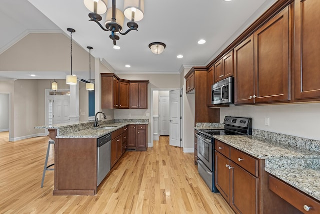 849 Graysville Rd, Chattanooga, TN 37421 - kitchen with appliances with stainless steel finishes, a sink, a kitchen bar, light wood-style flooring, and vaulted ceiling