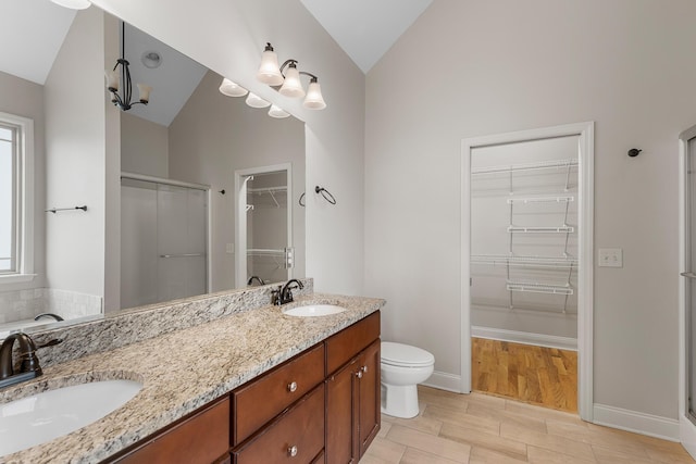 849 Graysville Rd, Chattanooga, TN 37421 - full bathroom featuring lofted ceiling, a walk in closet, a stall shower, double vanity, and wood finished floors