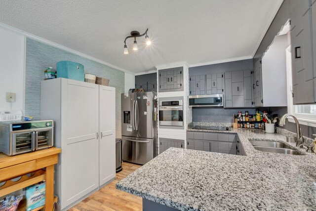 2729 Heights Circle Rd, Greenbrier, TN 37073 - kitchen featuring appliances with stainless steel finishes, a sink, crown molding, light wood finished floors, and light stone counters