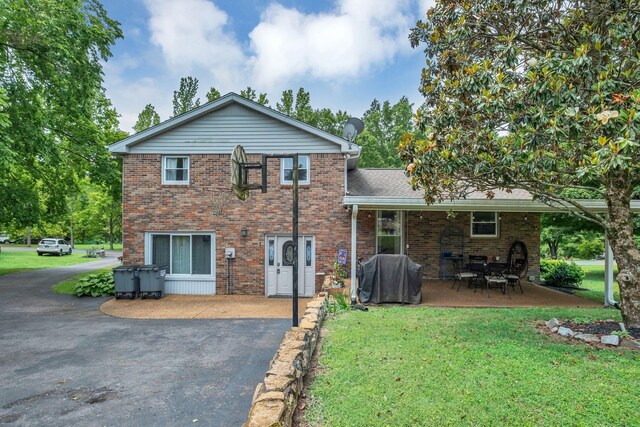 2729 Heights Circle Rd, Greenbrier, TN 37073 - back of property featuring a lawn, brick siding, a patio area, and asphalt driveway