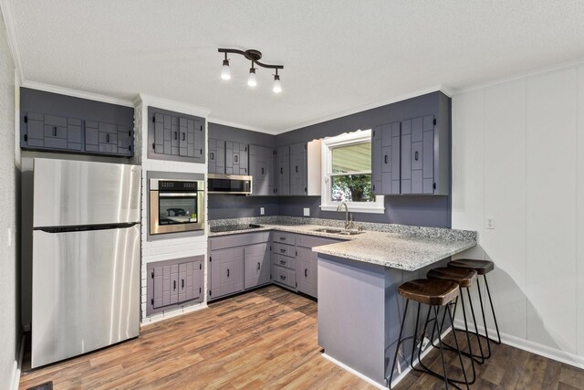 2729 Heights Circle Rd, Greenbrier, TN 37073 - kitchen featuring appliances with stainless steel finishes, gray cabinetry, a sink, a peninsula, and ornamental molding