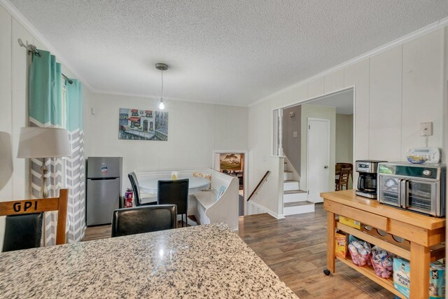 2729 Heights Circle Rd, Greenbrier, TN 37073 - kitchen featuring crown molding, a textured ceiling, freestanding refrigerator, wood finished floors, and a decorative wall