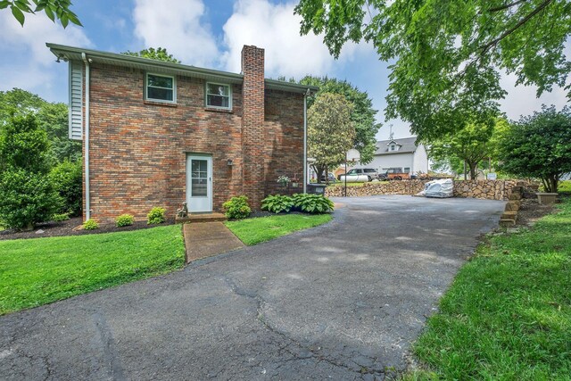 2729 Heights Circle Rd, Greenbrier, TN 37073 - view of front facade with a chimney, driveway, brick siding, and a front lawn