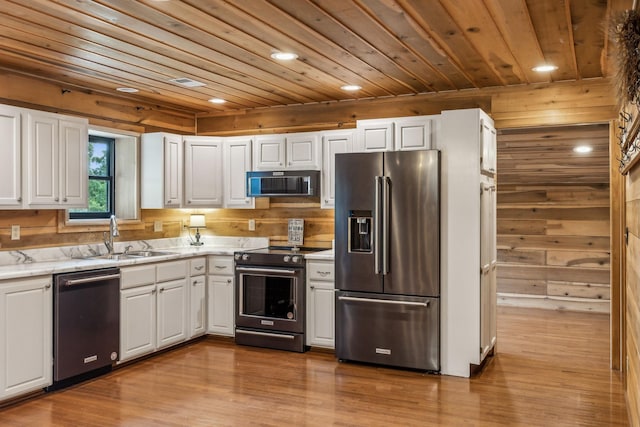 210 S 3rd St, Dickson, TN 37055 - kitchen with stainless steel appliances, a sink, wood ceiling, white cabinets, and wooden walls