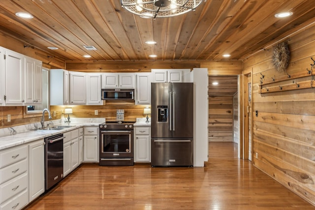 210 S 3rd St, Dickson, TN 37055 - kitchen with stainless steel appliances, a sink, wooden ceiling, recessed lighting, and wooden walls