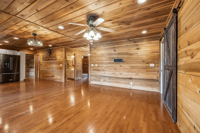 210 S 3rd St, Dickson, TN 37055 - unfurnished living room featuring wooden ceiling, wood walls, hardwood / wood-style flooring, a ceiling fan, and a barn door