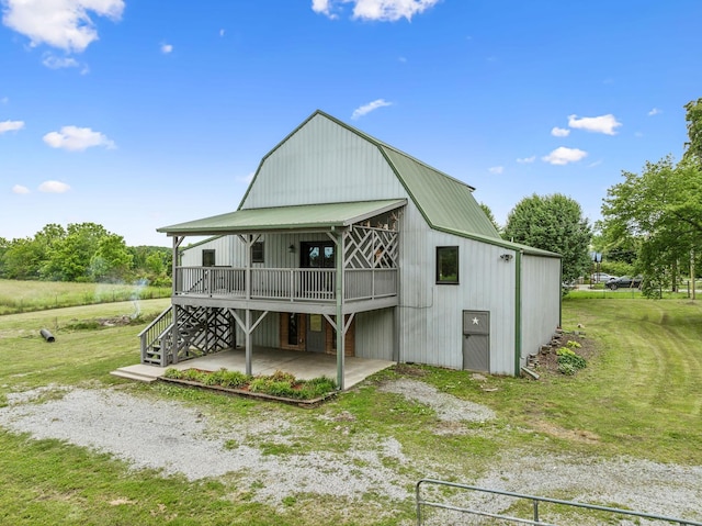 210 S 3rd St, Dickson, TN 37055 - rear view of house with metal roof, a lawn, a wooden deck, driveway, and a gambrel roof