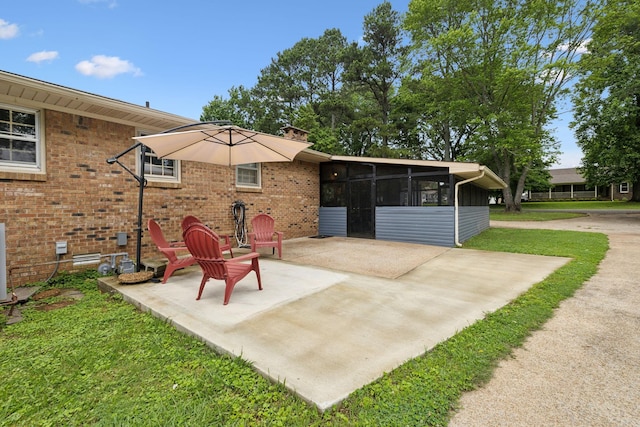 1106 5th Ave, Lawrenceburg, TN 38464 - rear view of house with a sunroom, a patio area, brick siding, and a chimney