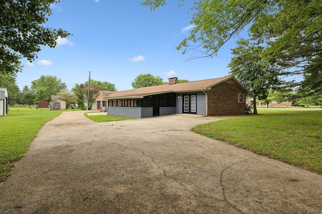 1106 5th Ave, Lawrenceburg, TN 38464 - view of front of home featuring a sunroom, driveway, a front lawn, and a chimney