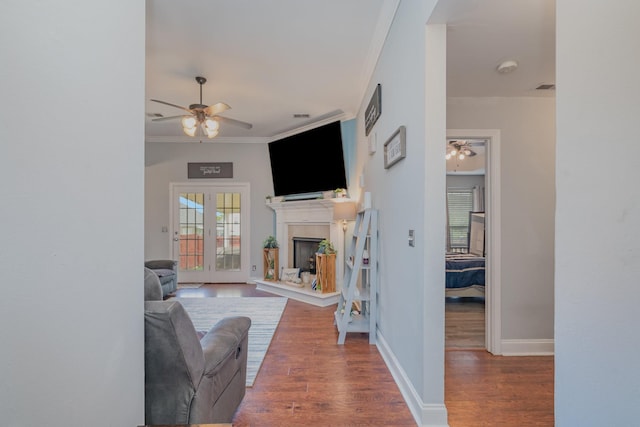 409 Princeton Dr, Lebanon, TN 37087 - living room with a ceiling fan, wood finished floors, a fireplace with raised hearth, baseboards, and crown molding