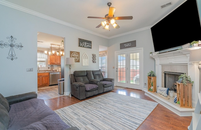 409 Princeton Dr, Lebanon, TN 37087 - living room featuring ornamental molding, light wood-type flooring, ceiling fan, a high end fireplace, and a chandelier