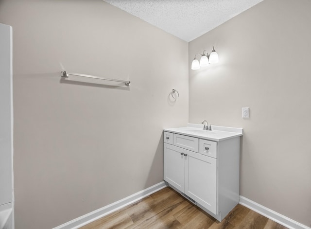 517 Overton Dr, Clarksville, TN 37042 - bathroom with wood finished floors, vanity, baseboards, and a textured ceiling