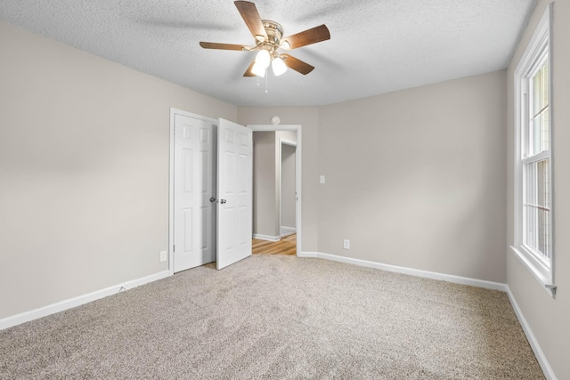 517 Overton Dr, Clarksville, TN 37042 - unfurnished bedroom featuring light carpet, multiple windows, a textured ceiling, baseboards, and ceiling fan