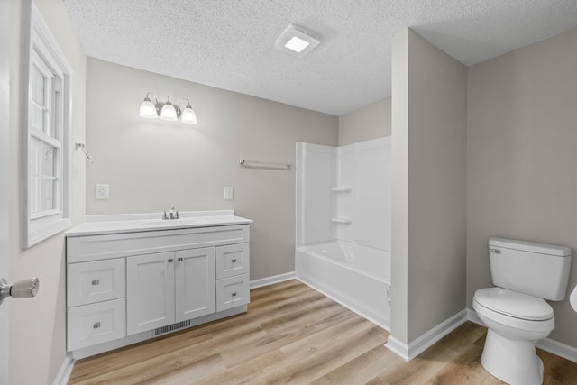 517 Overton Dr, Clarksville, TN 37042 - bathroom with wood finished floors, a textured ceiling, toilet, vanity, and baseboards