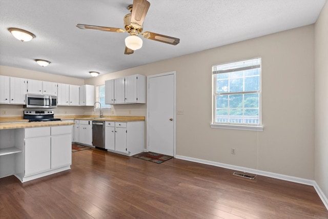 3554 Mountain Creek Rd, Chattanooga, TN 37415 - kitchen featuring stainless steel appliances, dark wood finished floors, baseboards, white cabinetry, and a textured ceiling