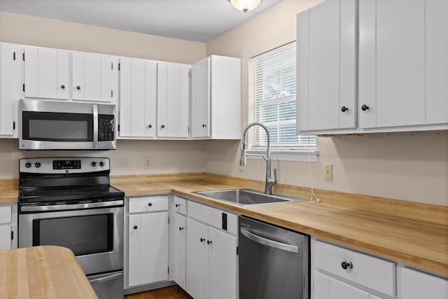 3554 Mountain Creek Rd, Chattanooga, TN 37415 - kitchen featuring stainless steel appliances, a sink, white cabinetry, and wood counters